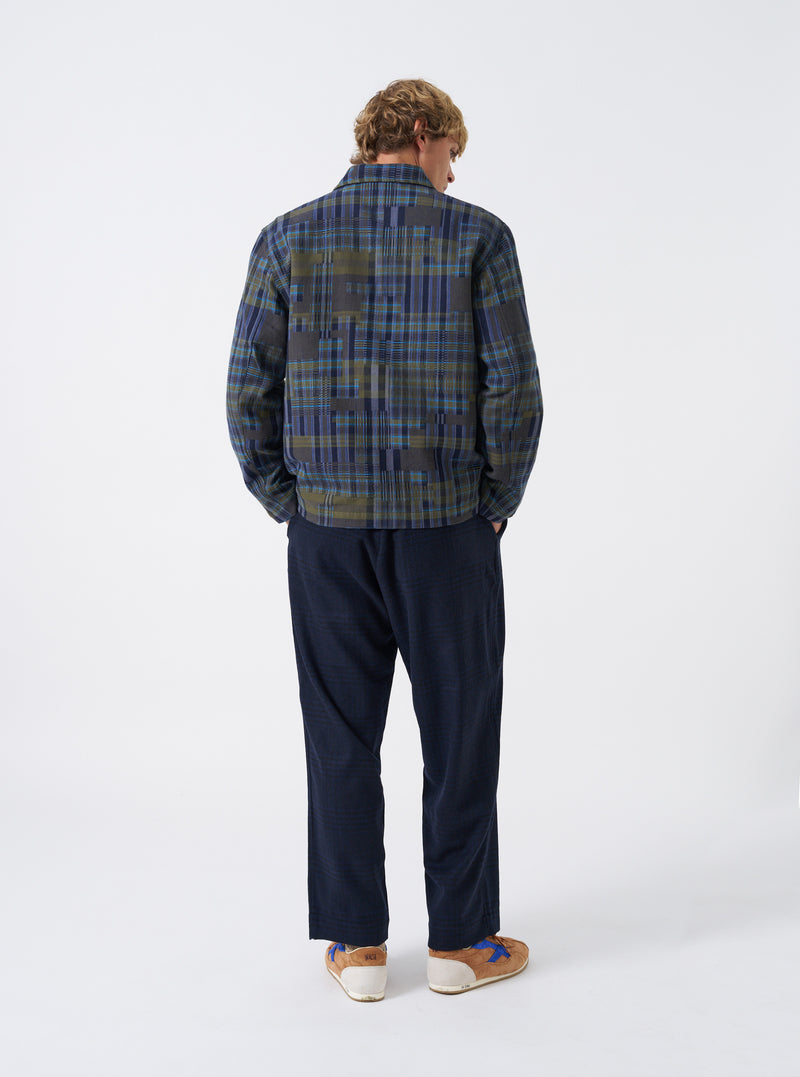 A front view of a model wearing the Olive Shadows Check Franck Jacket. The olive green suiting jacket features a subtle shadow check pattern, tailored lapels, button closure, and front patch pockets set against a plain background.