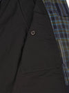 A close up product image of the Olive Shadows Check Franck Jacket against a plain background. The photo displays the olive green checked cotton fabric texture, detailed stitching around the collar, lapel, and top button closure.