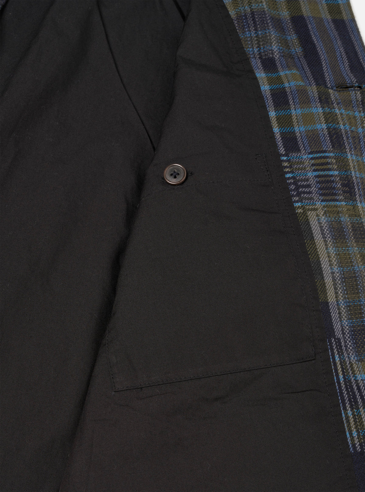 A close up product image of the Olive Shadows Check Franck Jacket against a plain background. The photo displays the olive green checked cotton fabric texture, detailed stitching around the collar, lapel, and top button closure.