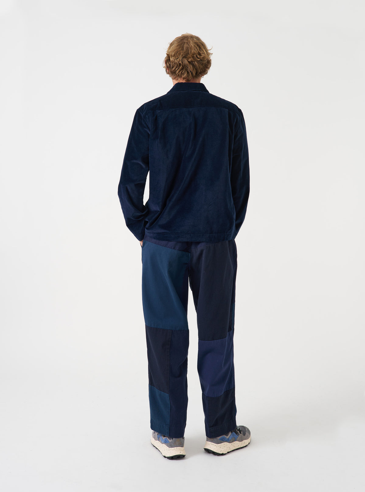 A back view of a model wearing the Navy CPH Velvet Zip OS Shirt. The image highlights the deep navy blue velvet fabric, back yoke detail, and casual fit of the long sleeve zip shirt set against a plain background.