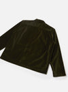 Back view of an olive velvet zip shirt, laid flat on a light grey surface. The smooth, lustrous velvet fabric shows light-catching sheen across the back panel and long sleeves. A rear yoke seam runs across the upper back, and a small welt pocket sits at the lower right. The cuffs are plain with no visible buttons.