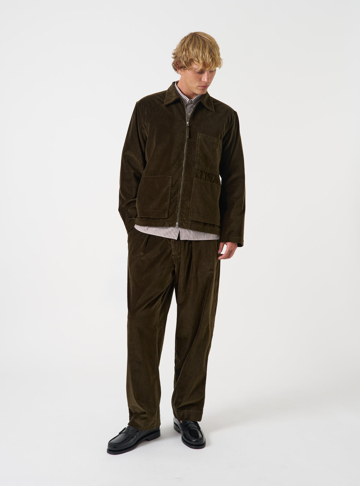 A front view of a model wearing the Olive CPH Velvet Zip OS Shirt. The olive green velvet overshirt features a front metal zip fastening, neat collar, long sleeves, and soft textured finish against a plain neutral backdrop.