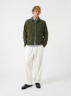A front view of a model wearing the Ecru CPH Velvet Oxford Pant. The light off-white velvet trousers feature a loose wide-leg fit, pleated front detailing, and drawstring waist shown against a plain neutral studio backdrop.