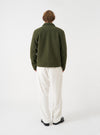A back view of a model wearing the Ecru CPH Velvet Oxford Pant. The image showcases the rear cut of the ecru cotton velvet trousers, highlighting the wide leg shape, soft fabric texture, and clean finish against a plain background.