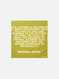 A square Light Olive Jazz/Beatniks Print Neckerchief displayed flat on a clean neutral background. Crafted from cotton, it features a bold graphic text pattern across the fabric surface.