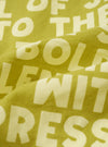 A close-up fabric swatch view of the Light Olive Jazz/Beatniks Print Neckerchief on a solid backdrop, detailing the light olive tone, jazz graphic print, and fine cotton fabric texture.