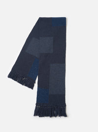 The Navy British Wool Scarf laid out flat against a clean, neutral studio background. Crafted from warm navy British wool, the rectangular scarf features ribbed ends and a clean, minimalist design.