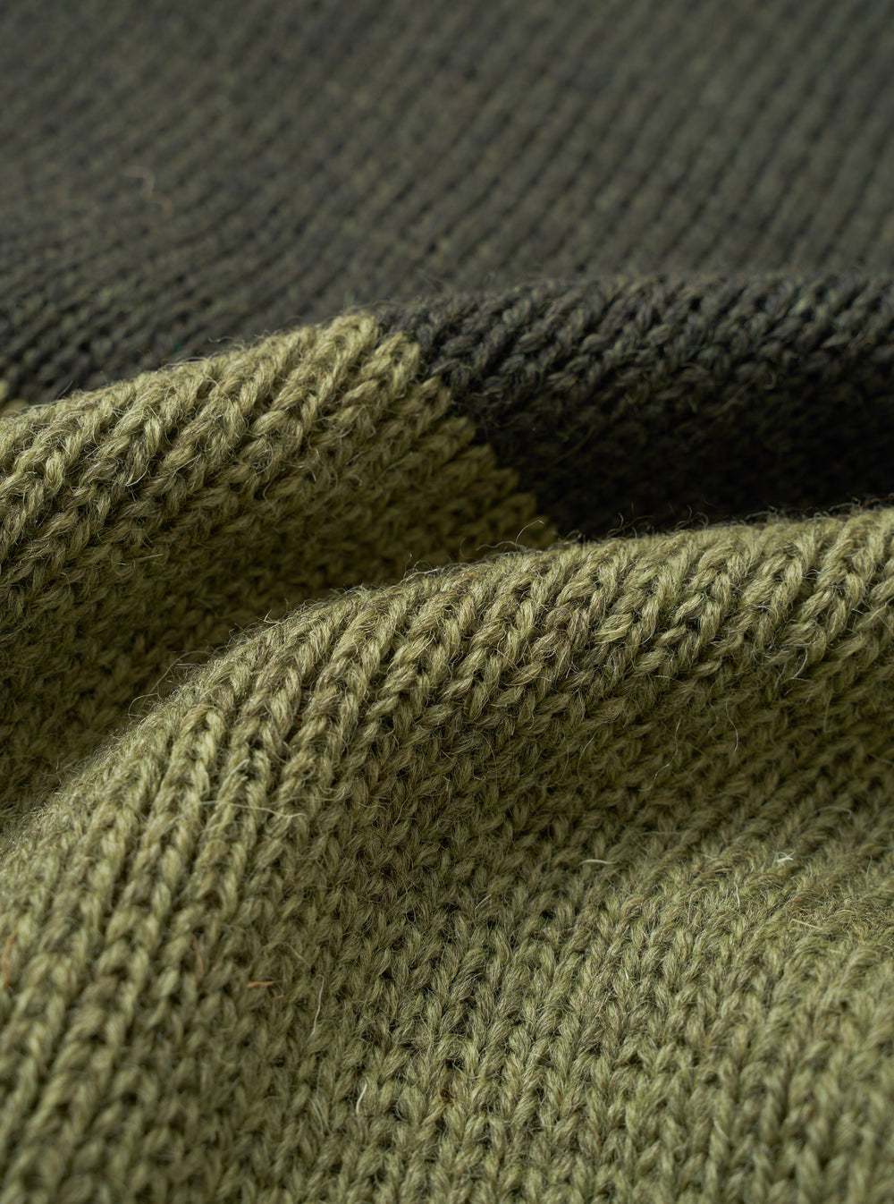 A detailed close-up swatch image of the Olive British Wool Scarf against a plain background, focusing on the olive green British wool fabric texture and finely finished edge detailing.