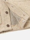 A close-up detail image of the Fawn Wool Fleece Advance Cardigan against a light background, focusing on the button-front placket, fine edge binding, patch pocket, and soft fawn fleece fabric structure.