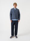A model wearing the Slate Blue Wool Fleece Advance Cardigan against a plain studio background. The cardigan is buttoned up, demonstrating its modern loose fit, V-neck collar, and front patch pockets.