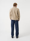 A male model wears the Fawn Wool Fleece Rams Jacket turned slightly to the side against a neutral backdrop, highlighting the loose silhouette, dropped shoulders, and neat cuff detailing on the jacket.