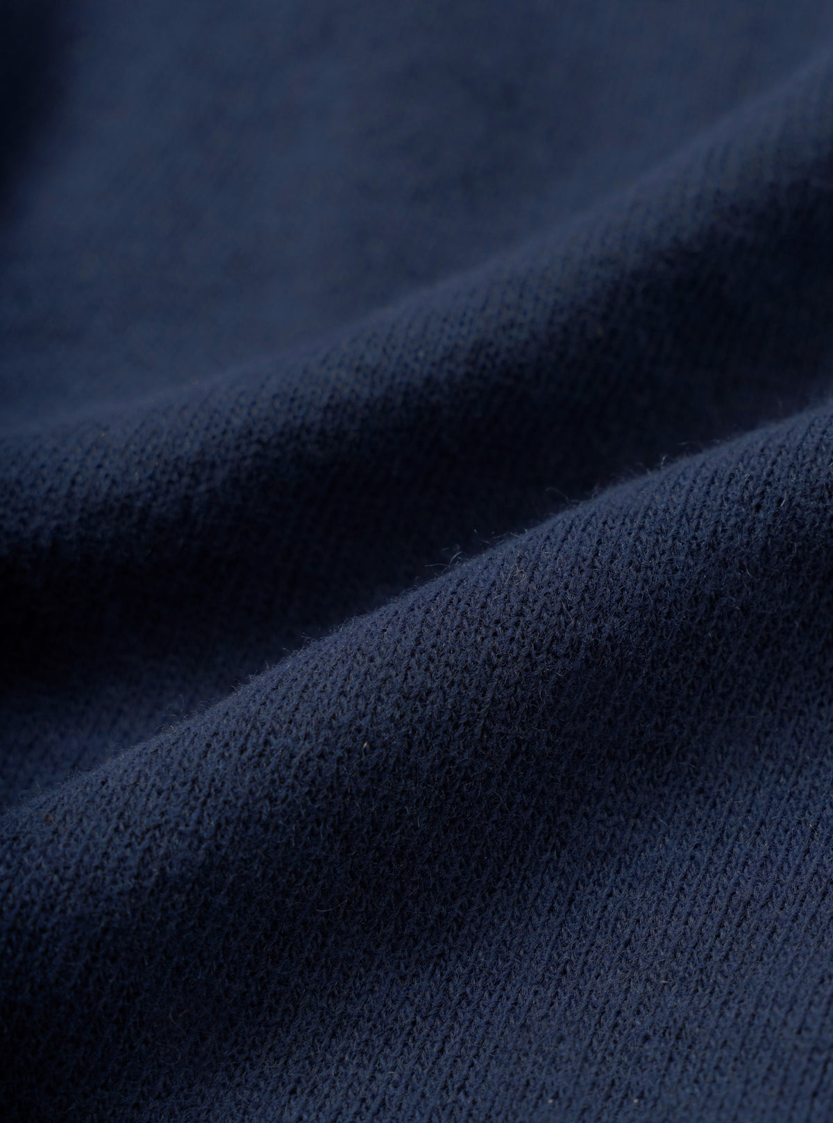 Close-up fabric swatch image of the Dark Navy Recycled Wool Mix SJ Pullover L/S Shirt, showcasing the fine single jersey knit texture and dark navy heathered wool mix material on a light background.