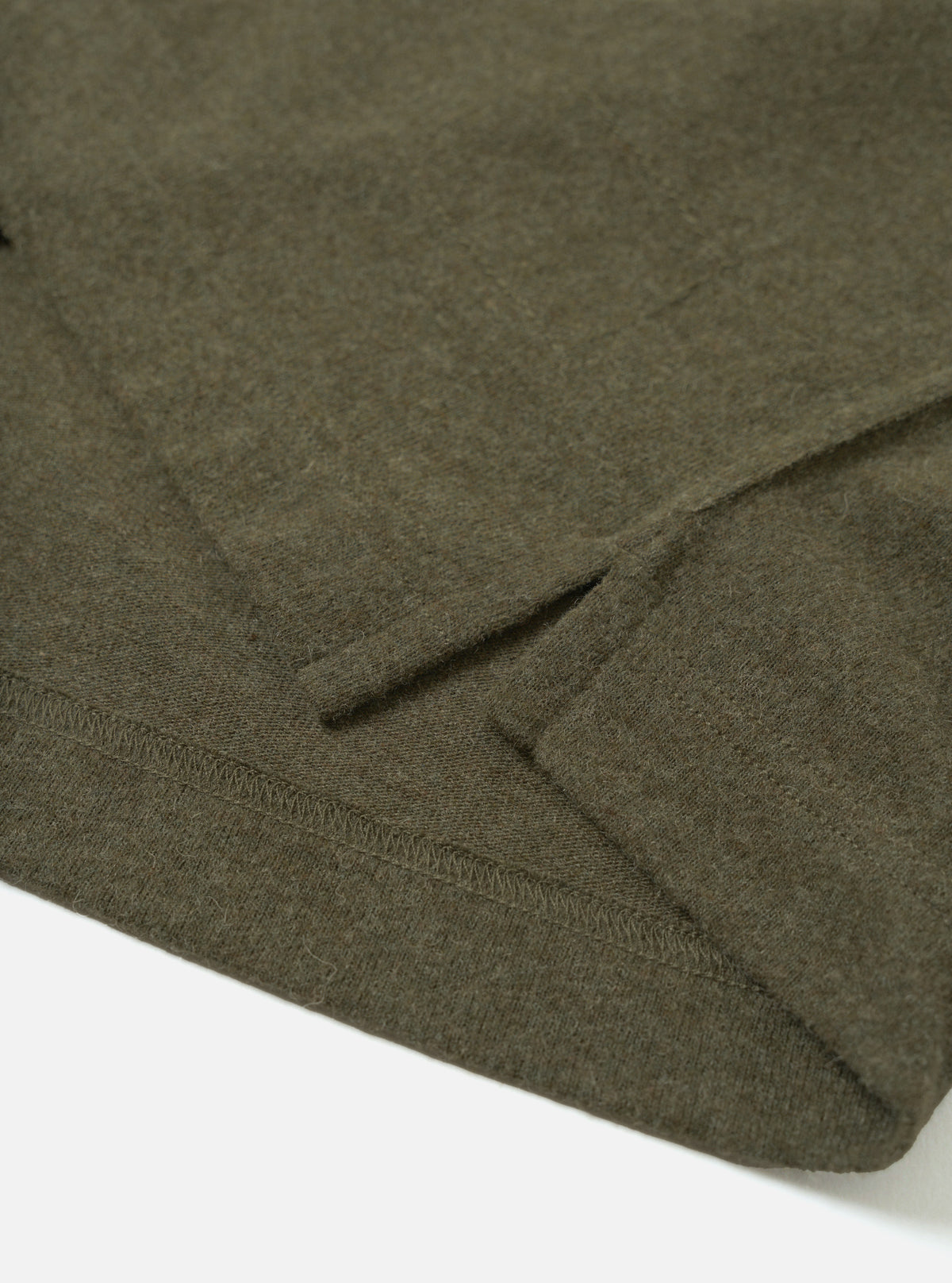 Detail view of the Olive Recycled Wool Mix SJ Pullover L/S Shirt on a plain background, showing the classic shirt collar, four-button closure, chest patch pocket, and textured olive jersey knit.