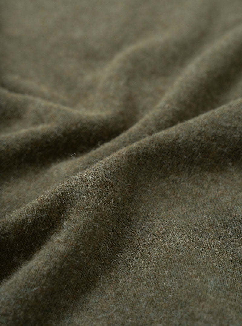 Close-up fabric swatch of the Olive Recycled Wool Mix SJ Pullover L/S Shirt, displaying the olive green heathered finish and fine weave of the recycled wool and polyester blend single jersey.
