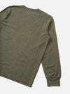 Rear three-quarter flat lay of an olive marl long-sleeve pocket tee on a plain white studio surface. The shot shows the back panel and right sleeve in full, with a crew neckline visible at the top. The ribbed cuff is clearly visible at the sleeve end. Fabric has a heathered wool-mix texture throughout.