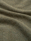 Close-up detail shot of the olive recycled wool mix fabric used in the pocket tee. The mélange knit shows a soft, brushed surface with fine fibres visible across its texture. Gentle folds in the fabric highlight its weight and drape.