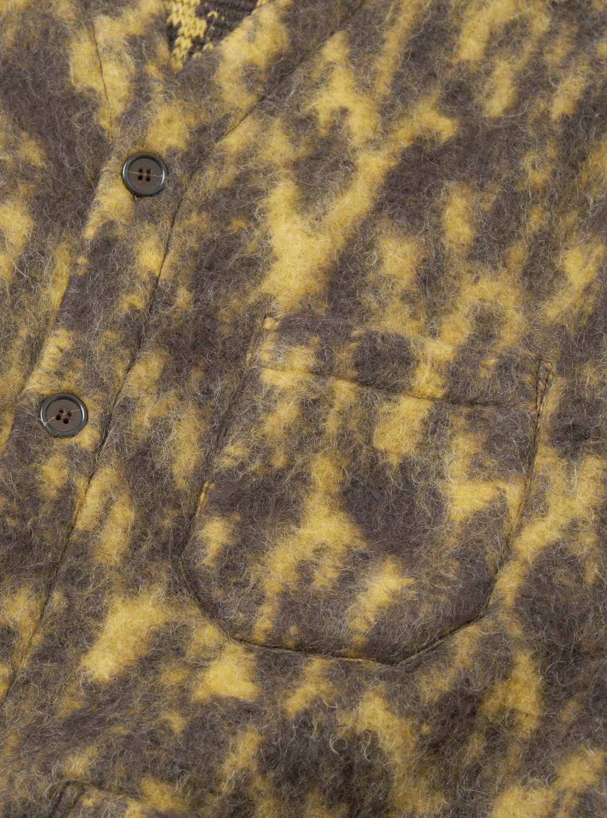 A close-up detail shot of the Brown Dolce Fleece Cardigan on a model against a plain light background, showcasing the v-neck collar, front button fastening, patch pocket styling, and tactile wool-blend fleece texture.