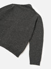 A male model viewed from the rear wearing the Black Wool Fleck Langdale Cardigan against a plain white studio backdrop, highlighting the loose fit silhouette and textured black yarn with subtle flecked detail.