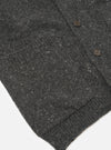 A close-up image of a model wearing the Black Wool Fleck Langdale Cardigan on a neutral background, highlighting the button placket, V-neck styling, textured knit finish, and flecked yarn details.