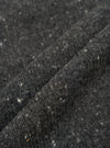 A fabric swatch close-up image of the Black Wool Fleck Langdale Cardigan on a plain light background, highlighting the rich black wool blend base adorned with characteristic subtle multi-colored flecks.