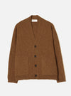 A male model wearing the Brown Wool Fleck Langdale Cardigan against a plain light background. The front view highlights the loose relaxed fit, button closure, patch hand pockets, and warm brown flecked knit fabric.
