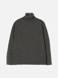 A model wearing the Black Wool Fleck Roll Neck against a neutral studio background. The knitwear piece features a cozy high roll neck, ribbed trim details, and a subtle flecked texture across the recycled wool fabric.