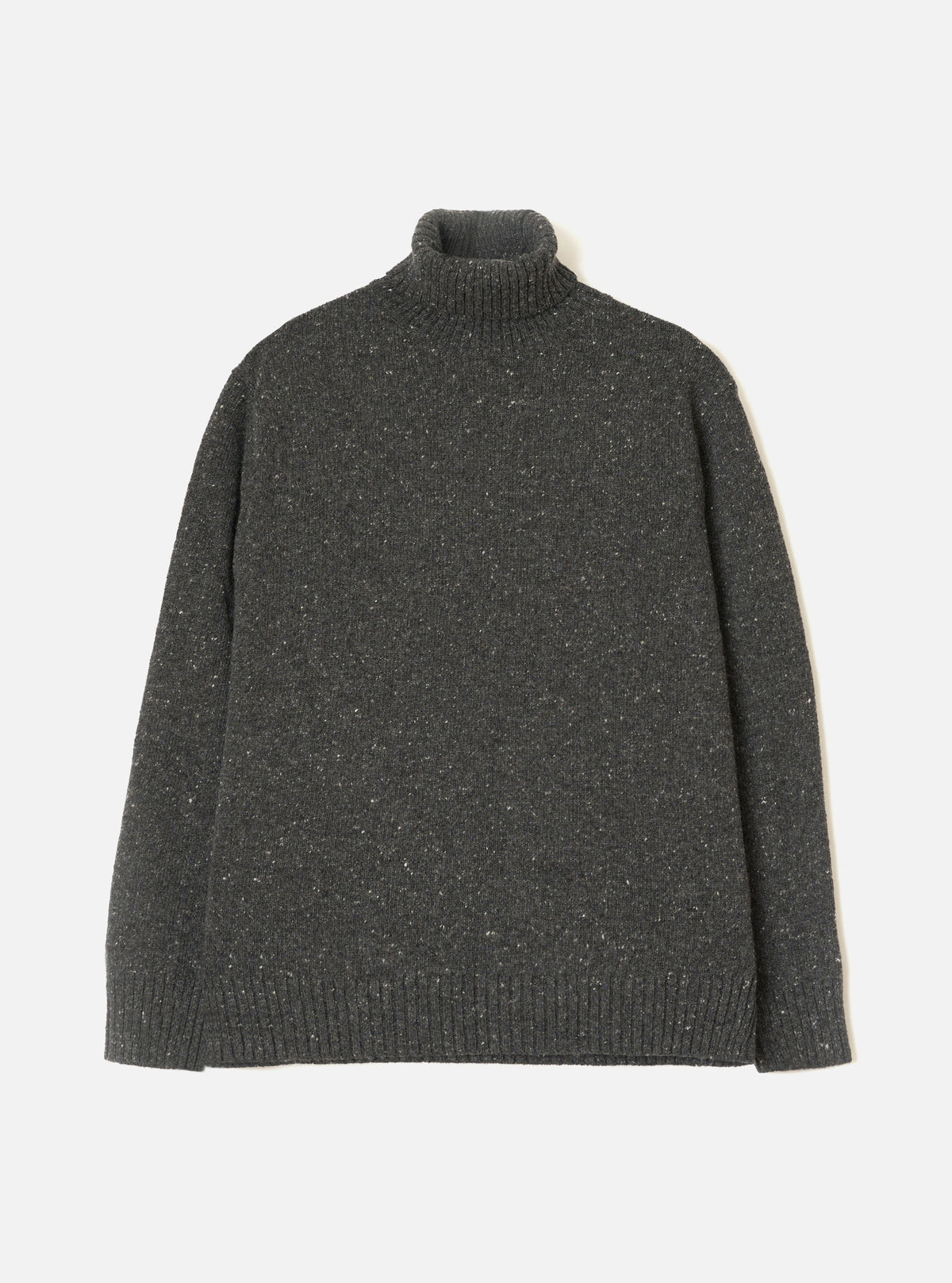 A model wearing the Black Wool Fleck Roll Neck against a neutral studio background. The knitwear piece features a cozy high roll neck, ribbed trim details, and a subtle flecked texture across the recycled wool fabric.