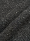 A close-up fabric swatch view of the Black Wool Fleck Roll Neck on a light backdrop, emphasizing the rich black recycled wool material integrated with subtle flecked texture details throughout.