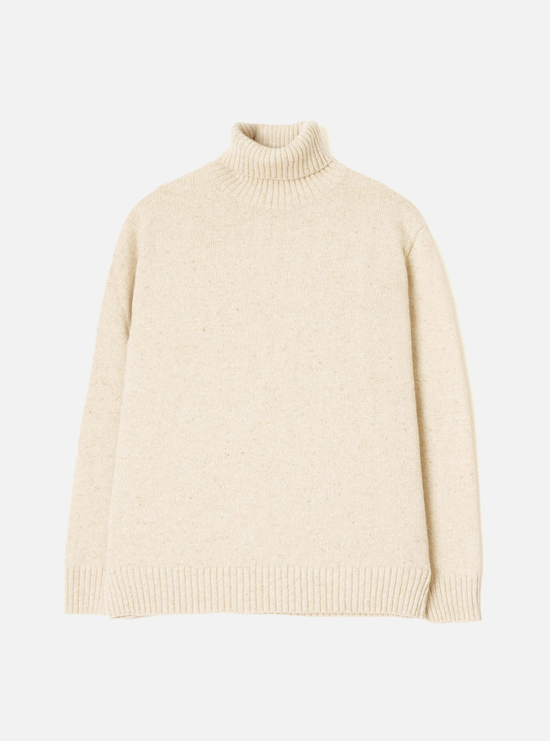 A model wearing the Fawn Wool Fleck Roll Neck against a plain studio background. The jumper showcases a high roll neck collar, long sleeves, ribbed hem, and a subtle flecked recycled wool pattern.