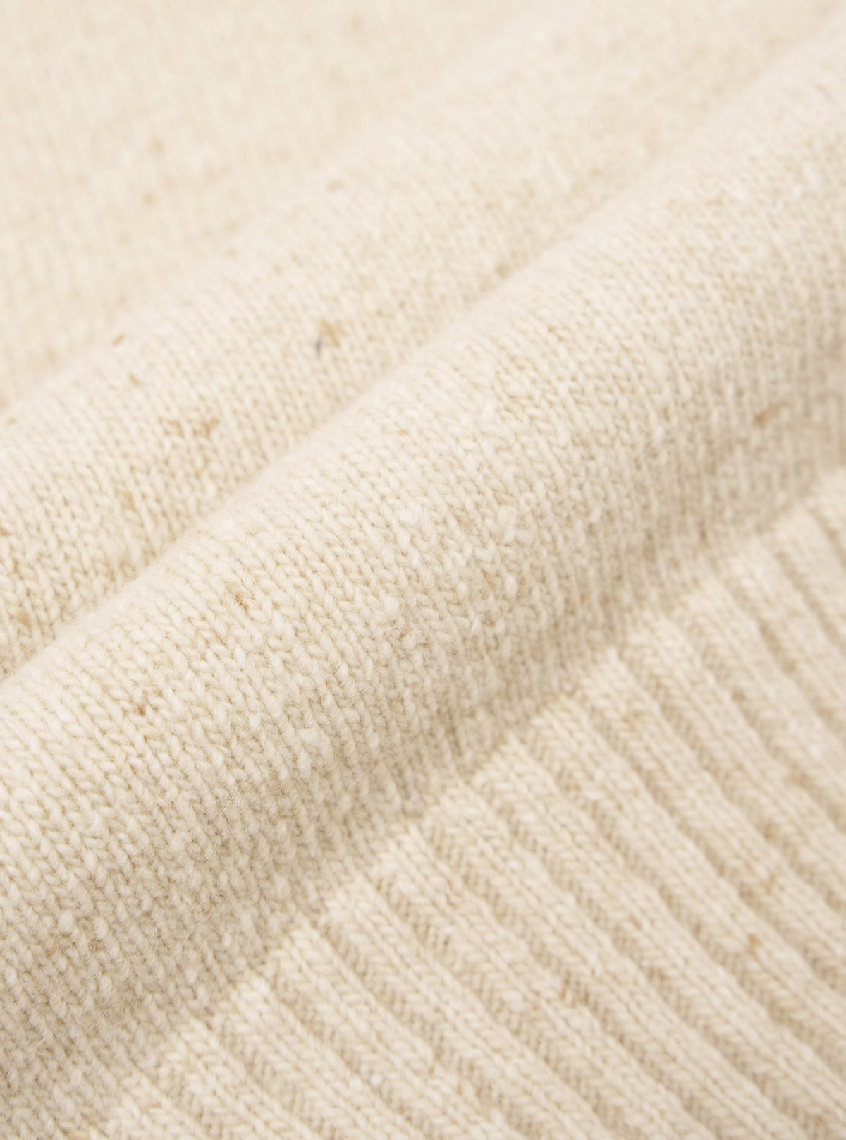 A close-up swatch image of the Fawn Wool Fleck Roll Neck fabric, detailing the soft tactile finish, warm fawn color shade, and delicate flecked recycled wool knit pattern on a plain neutral ground.