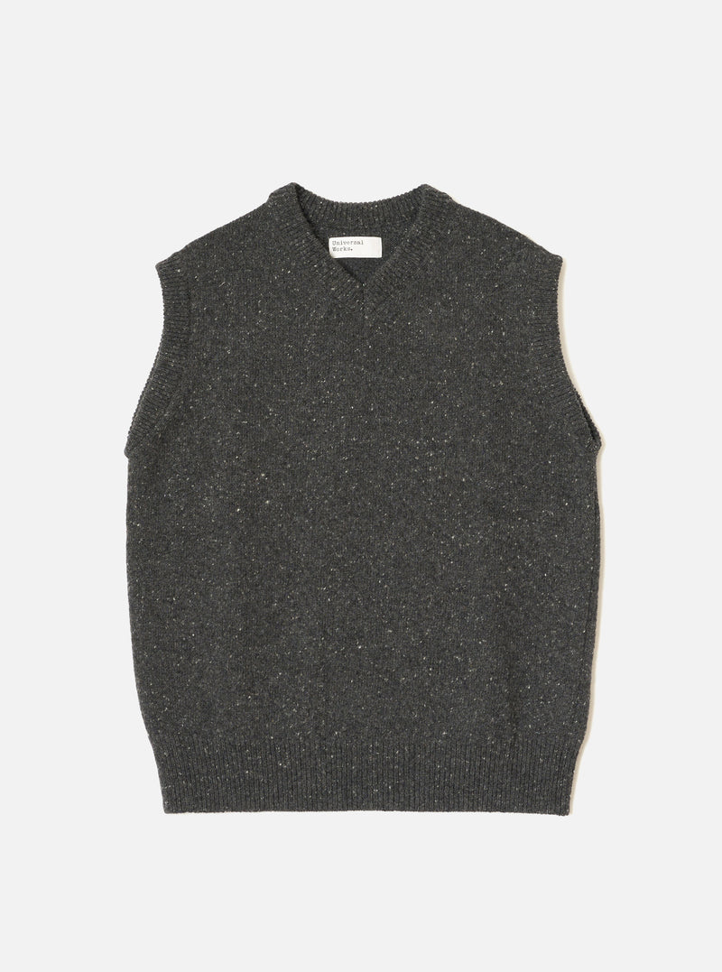 A model wearing the Black Wool Fleck Sweater Vest against a neutral studio backdrop. The sleeveless sweater vest features a classic V-neckline, ribbed hem, and subtle flecked recycled wool texture.