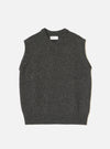 A model wearing the Black Wool Fleck Sweater Vest against a neutral studio backdrop. The sleeveless sweater vest features a classic V-neckline, ribbed hem, and subtle flecked recycled wool texture.