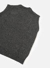 A side profile view of a model wearing the Black Wool Fleck Sweater Vest on a plain background, highlighting the sleeveless cut, neat armhole finishing, and textured dark fleece-flecked knit.