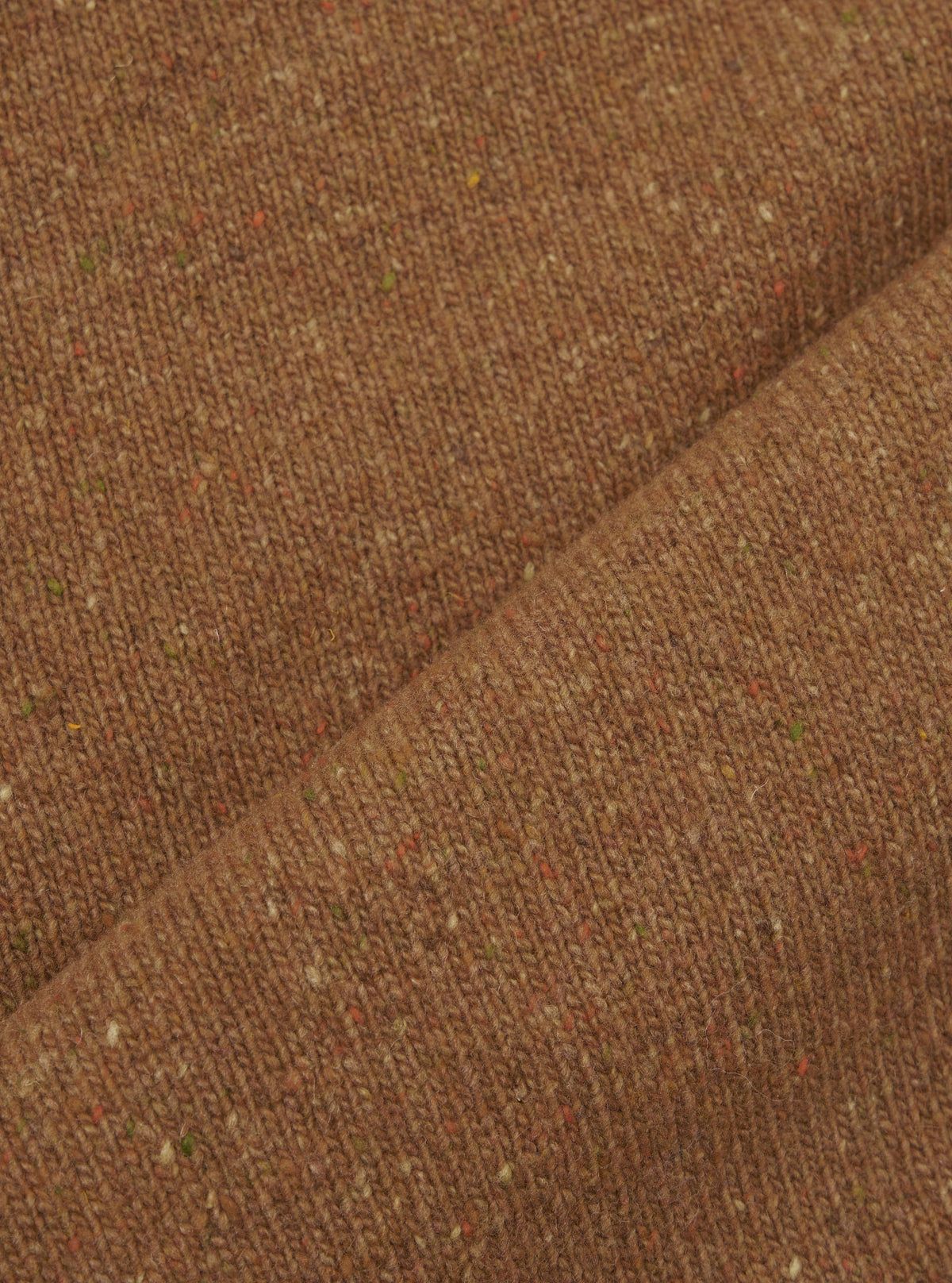A fabric swatch photograph of the Brown Wool Fleck Sweater Vest on a neutral surface, showcasing the deep brown recycled wool fibers blended with subtle multi-colored flecks throughout the weave.