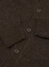 Close-up flat lay of the brown alpaca knit cardigan showing the button placket with three visible dark horn-effect four-hole buttons. The fluffy, hairy texture of the alpaca knit is prominent throughout. A ribbed front band runs along the placket edge, with the sleeve visible in the upper right corner.