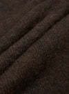 Close-up detail shot of the brown alpaca knit fabric of the David Cardigan, showing soft, fluffy fibres with a hairy, textured surface. Three gentle folds run diagonally across the frame, highlighting the fabric's depth and loft. The dark brown marl tone shows subtle variation throughout.