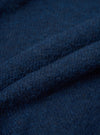 Close-up detail shot of the navy alpaca knit fabric, showing a soft, slightly hairy texture with a fine knit construction. The deep blue-navy yarn has subtle tonal variation. The fabric is loosely folded to show its depth and loft. No background is visible.