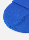 A close-up view of the Blue Merino Knit Watch Cap set against a plain background, focusing on the detailed ribbed knit construction, soft merino wool fibers, and neat finished edging of the turn-up cuff.