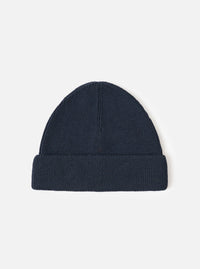 A full view of the Navy Merino Knit Watch Cap displayed against a clean white studio background. The deep navy blue knitted beanie features a thick folded cuff and a classic ribbed pattern throughout.