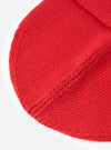 A close-up detailed view of the Red Merino Knit Watch Cap displayed against a clean white background. The image highlights the rich red knitted merino wool texture, fine stitch details, and the folded cuff of the hat.
