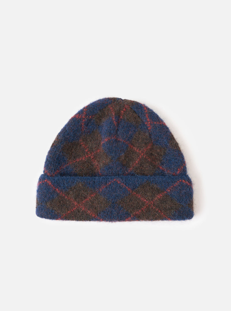 A full front view of the Navy Alpaca Argyle Argyll Hat set against a plain white background. The soft alpaca blend knit cap features a classic argyle pattern in dark navy blue with contrasting geometric details and a folded cuff.