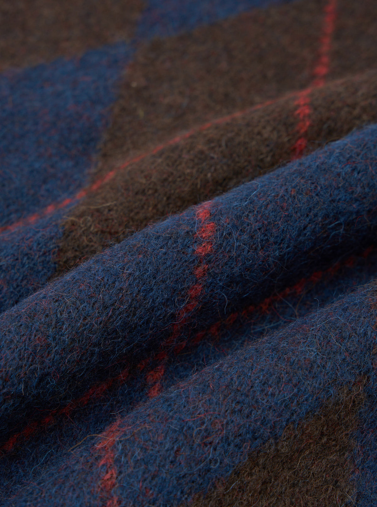 An extreme close-up fabric swatch image of the Navy Alpaca Argyle Lyon Crew material. The photo emphasizes the soft, brushed texture of the alpaca blend knit, showing dark navy fibers woven into a traditional argyle pattern.