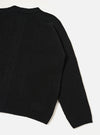 A rear view of the Black Eco Wool Zip Cardigan shown against a solid white background. The black and grey wool-blend cardigan highlights a clean back panel, set-in sleeves, structured funnel neckline, and neatly ribbed hemline.