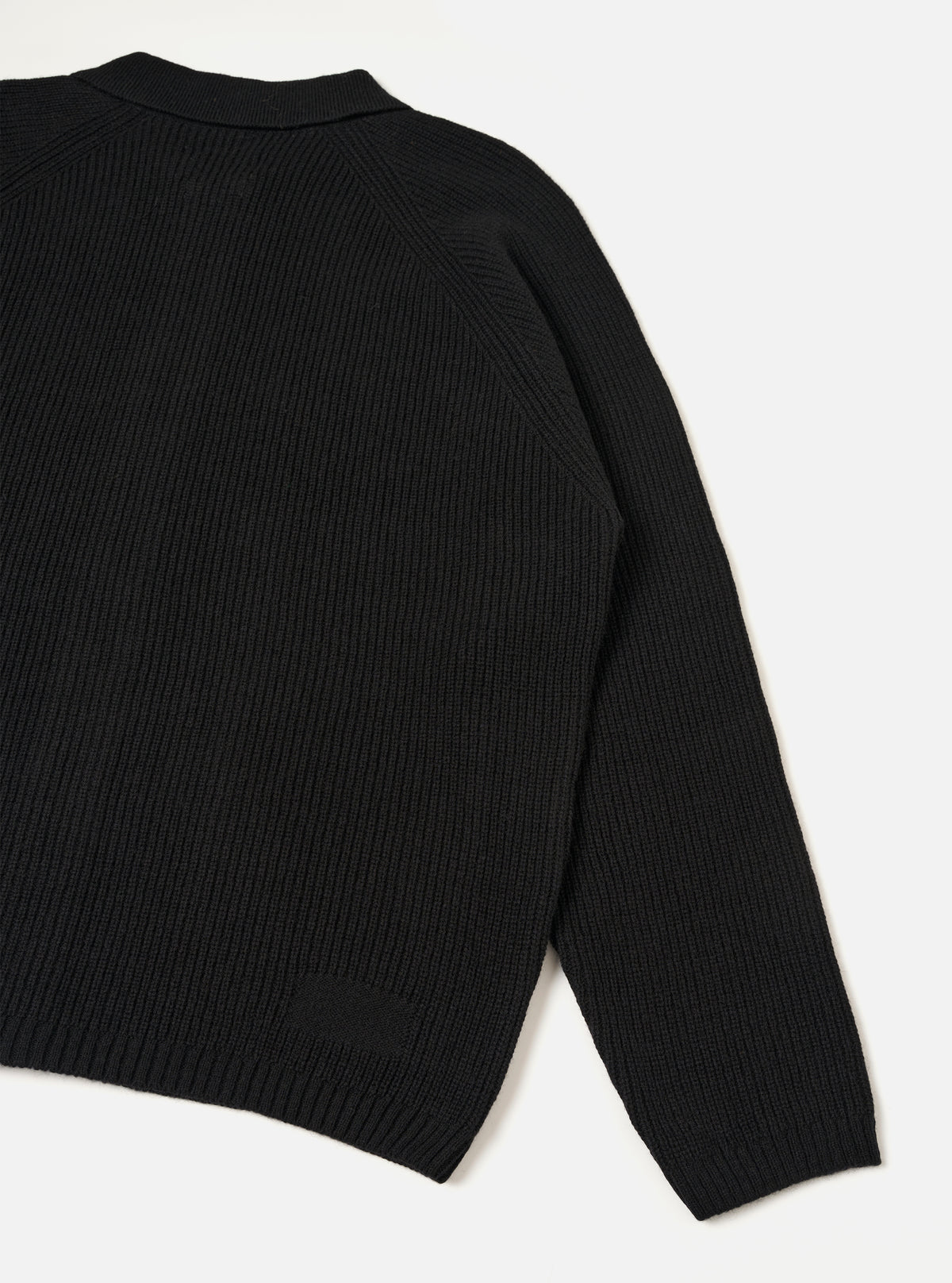 A rear view of the Black Eco Wool Zip Cardigan shown against a solid white background. The black and grey wool-blend cardigan highlights a clean back panel, set-in sleeves, structured funnel neckline, and neatly ribbed hemline.