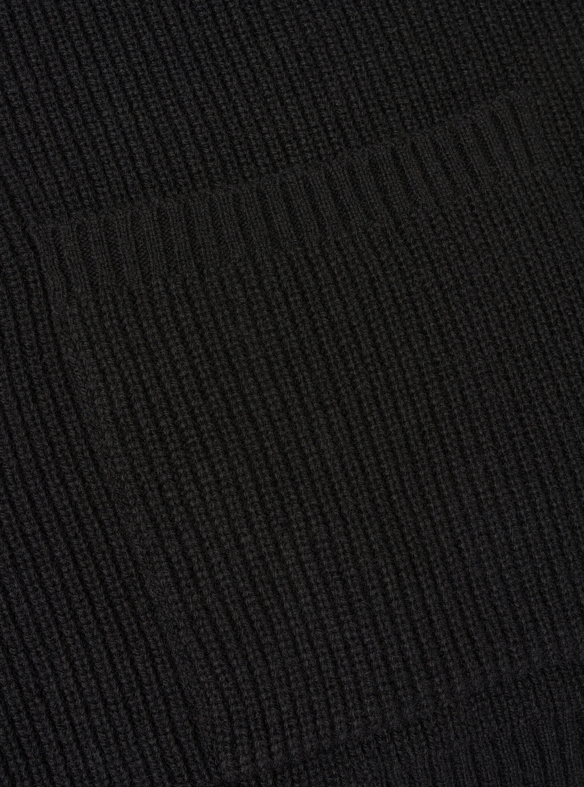 A close-up angle of the Black Eco Wool Zip Cardigan against a plain white studio background. The image highlights the fine ribbed knit cuffs, hemline stitching, and rich black eco wool yarn texture of the long-sleeved garment.