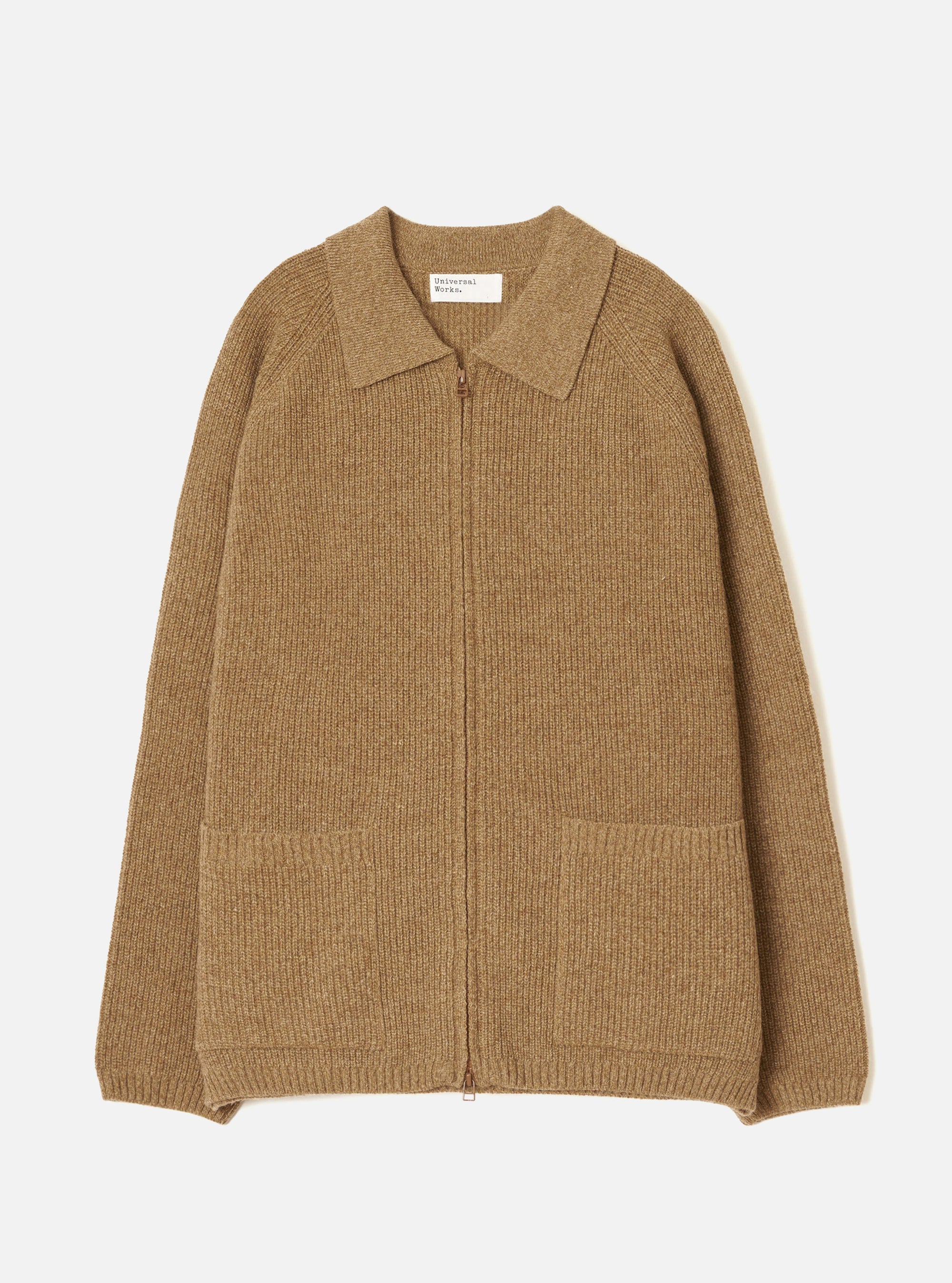 Tawny eco wool zip cardigan in camel marl, flat lay on a light grey seamless backdrop. Ribbed knit throughout with a spread collar, full-length bronze zip and two patch pockets at the hem. Ribbed cuffs and hem band. Universal Works woven label at the neckline.