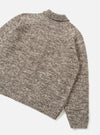 A rear view of the Ecru/Brown Lambswool Zip Cardigan shown on a plain white studio background. The knit garment highlights the smooth back panel construction, set-in long sleeves, and contrasting brown and ecru wool patterning.