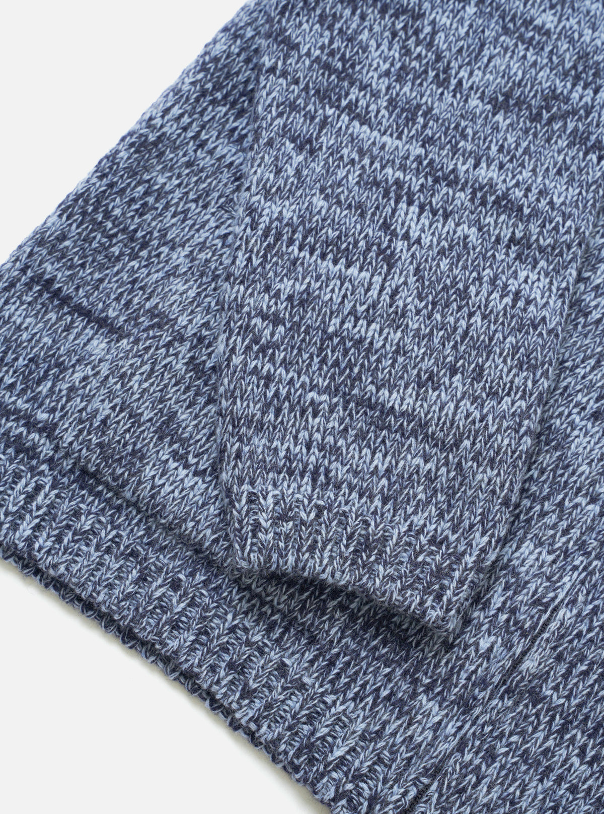 Close-up detail shot of the Sky/Navy Lambswool Zip Cardigan set against a white studio background. The image showcases the two-way front zip zipper, collar, and soft marled lambswool knit fabric structure in sky blue and navy.
