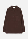 Espresso brown merino knit pullover shirt laid flat on a white studio backdrop. Features a pointed polo collar, four-button placket, single patch chest pocket, long sleeves with ribbed cuffs, and a ribbed hem. Universal Works woven label visible at the back neck.