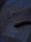 Close-up detail shot of the Navy British Wool Lyon Crew sweater against a plain white background. Highlights the ribbed crew neckline, raglan sleeve stitching, and deep texture of the premium marled navy blue British wool yarn.